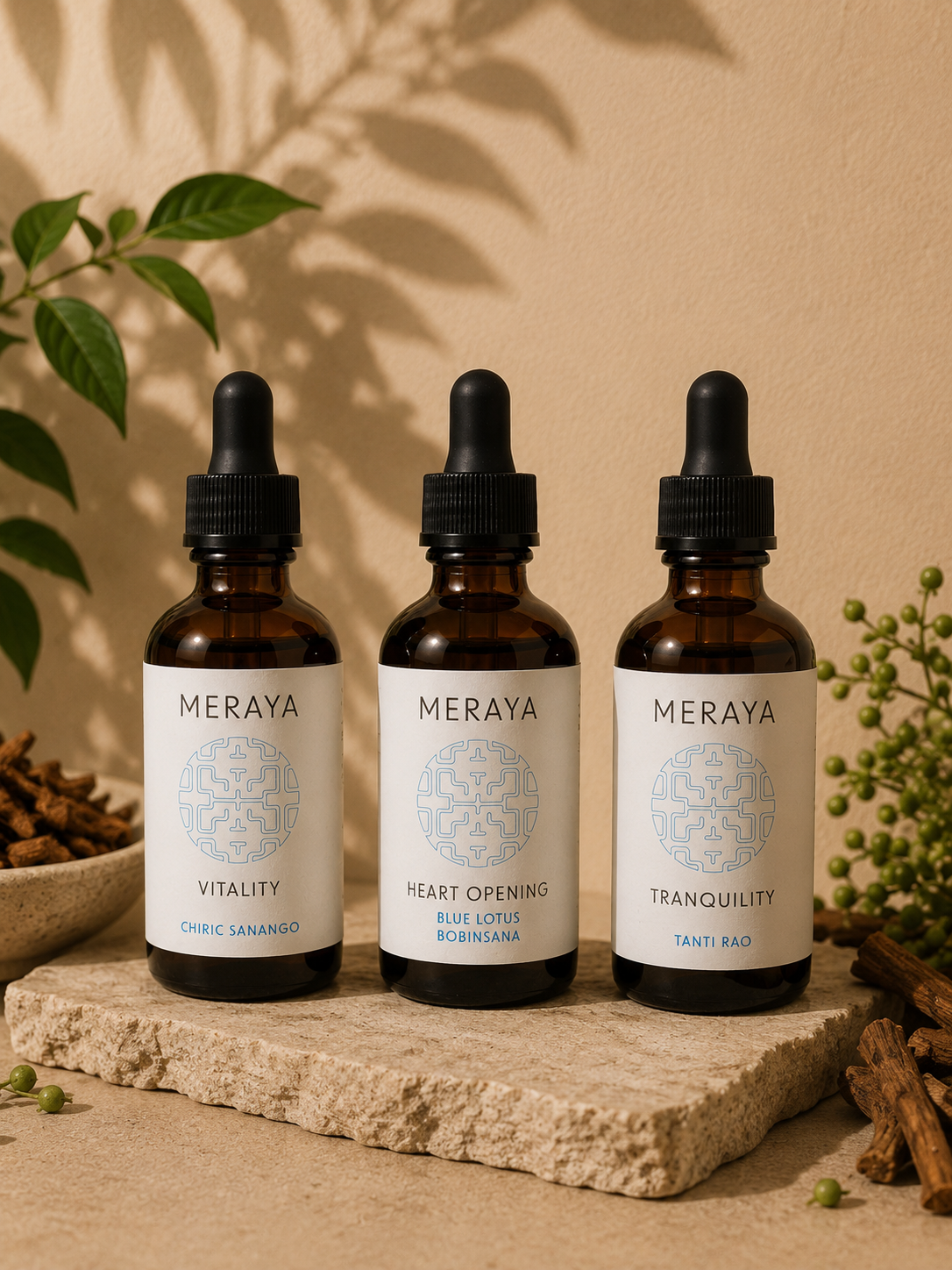 Three amber glass dropper bottles with white labels from the brand MERAYA, arranged on a stone slab with botanical props against a warm beige wall.