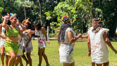 Group of women in traditional attire shipibo dancing outdoors in a natural setting