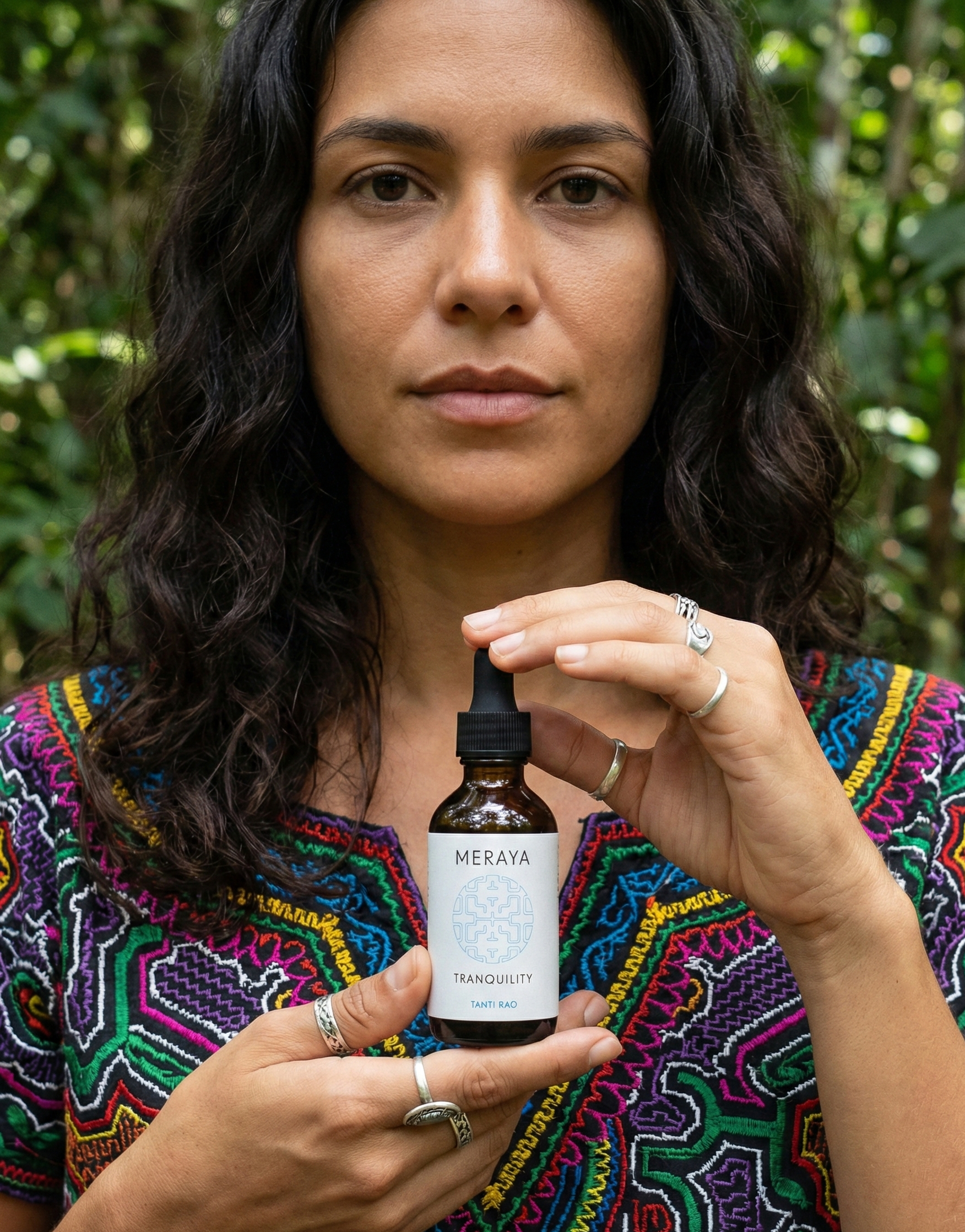 Woman holding a bottle of Meraya products against a natural background
